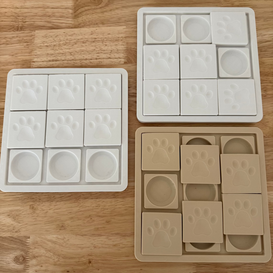 Three dog enrichment toys on a wooden surface, one white and two beige.